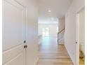 Hallway leads to an open floor plan featuring light wood floors and a staircase at 4057 Lawnview Dr, Charlotte, NC 28269