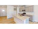 Charming kitchen features an island, stainless steel appliances, and gray cabinets at 4057 Lawnview Dr, Charlotte, NC 28269