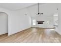 Bright living room boasts a fireplace, ceiling fan, vaulted ceiling, and light wood floors at 2059 Parks Rd, Salisbury, NC 28147