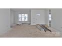 Spacious room with a large window and white walls awaiting finishing touches. Ladders on floor at 2059 Parks Rd, Salisbury, NC 28147