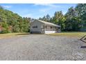 Single story home on a gravel driveway with mature trees nearby at 335 Adolphus Rd, Salisbury, NC 28146