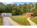 Exterior view of a brick home and detached garage with a spacious yard and gravel driveway at 5960/5930 S Main St, Salisbury, NC 28147