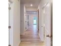 Bright hallway featuring light wood flooring and white doors leading to various rooms at 649 Kitfox Nw Dr, Concord, NC 28027