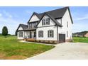 Beautiful two-story white home showcasing a side entry garage, landscaped front yard, and board and batten siding at 2025 Parks Rd, Salisbury, NC 28147