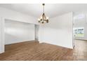 Spacious open-concept living area with wood floors, white walls, a modern chandelier, and abundant natural light at 2025 Parks Rd, Salisbury, NC 28147