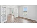 Bright living room with wood-look floors, glass paneled doors, and a large window at 317 Miramar Dr, York, SC 29745