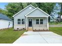 A cozy single-story house with a light-colored exterior, a small porch, and a well-maintained front yard at 602 Meadow Ave, Spencer, NC 28159
