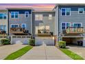 Rear view of townhomes showcasing private decks and attached garages at 11712 Blessington Rd, Huntersville, NC 28078