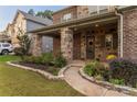 Charming covered front porch with stone pillars, a well-kept garden, and inviting entryway at 16827 Monocacy Blvd, Huntersville, NC 28078