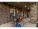 Inviting front porch with stone columns, rocking chairs, and colorful decor offering a cozy welcome at 16827 Monocacy Blvd, Huntersville, NC 28078