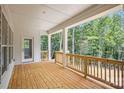 Covered porch with white ceiling and posts with wood railing looking out to a private wooded backyard at 552 Fern Hill Rd # 21, Mooresville, NC 28117