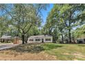 Curb view of cozy home featuring an established lawn and mature trees and landscaping at 1003 Woodland Dr, Gastonia, NC 28054