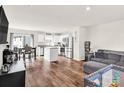 Open-concept living room featuring hardwood floors, a kitchen with stainless steel appliances, and a cozy seating area at 1197 Tangle Ridge Se Dr, Concord, NC 28025