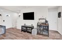 Modern living room showcasing sleek furniture, a mounted television, and a stylish bar cabinet at 1197 Tangle Ridge Se Dr, Concord, NC 28025