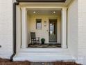 Inviting front porch with rocking chair, stone floor, and decorative details at 5704 Crescent Field Cir # 25, Huntersville, NC 28078