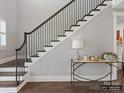 Elegant staircase featuring dark wood steps, white risers and trim, and decorative console table at 5704 Crescent Field Cir # 25, Huntersville, NC 28078
