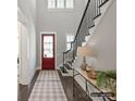 Welcoming foyer showcasing a red entry door, dark wood floors, staircase and stylish console table decor at 8111 Farm Crossing Ln # 2, Huntersville, NC 28078