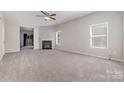 Spacious carpeted living room with a fireplace and ample natural light at 4803 Roxfield Ln, Charlotte, NC 28215