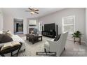 Staged living room featuring a fireplace, ceiling fan, and plenty of natural light at 4803 Roxfield Ln, Charlotte, NC 28215