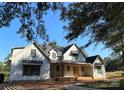 New construction home with a charming covered front porch and a view of mature trees at 104 Arbor Dr, Waxhaw, NC 28173