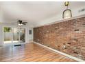 Living room with hardwood floors, exposed brick, and patio access at 1201 Green Oaks Ln # G, Charlotte, NC 28205