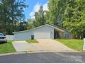 Gray sided home with a two-car garage and landscaped yard at 6001 Long Pine Dr, Charlotte, NC 28227