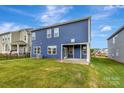 The home features a spacious backyard with a manicured lawn and covered patio, perfect for outdoor entertaining at 10132 Whitaker Pointe Dr, Huntersville, NC 28078