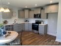 Modern kitchen with gray cabinets, stainless steel appliances, and quartz countertops at 202 Andrews St, East Spencer, NC 28039