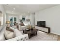 Bright living room boasts white sofas, hardwood floors, and an open floor plan connecting the kitchen and dining areas at 4132 Shamrock Dr, Charlotte, NC 28215