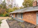 Side view of a brick home with trimmed windows and minimal landscaping at 110 Mimosa Rd, Statesville, NC 28677