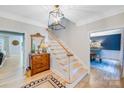 Bright foyer with hardwood floors, staircase, and decorative chandelier at 1134 Willow Oaks Trl, Matthews, NC 28104