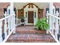 Charming front porch with brick steps, white railings, and potted fern at 1134 Willow Oaks Trl, Matthews, NC 28104