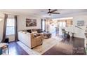 Spacious living room with L-shaped sofa and dark hardwood floors at 7324 Friar Tuck Ln, Mint Hill, NC 28227