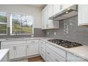 Modern kitchen features gray tile backsplash and gas cooktop at 112 Atterberry Aly, Charlotte, NC 28217