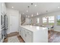 Open concept kitchen with island, white cabinets, and hardwood floors at 112 Atterberry Aly, Charlotte, NC 28217