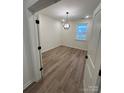 A bright bedroom featuring wood floors, a modern light fixture, and a view from the window at 3014 Cunningham Farm Dr, Indian Trail, NC 28079