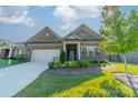 Beautiful brick home features a well-maintained lawn, professional landscaping, and an attached two-car garage at 2014 Newstyle Way, Tega Cay, SC 29708