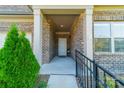 Inviting front porch with a brick exterior and a decorative black railing enhancing the home's curb appeal at 2014 Newstyle Way, Tega Cay, SC 29708
