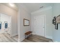 Bright hallway with wood floors, white walls, and a decorative mirror, leading to an adjacent bathroom at 2014 Newstyle Way, Tega Cay, SC 29708