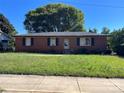 Traditional brick home featuring a classic design with a well-maintained lawn and mature trees at 1424 Montana Dr, Charlotte, NC 28216