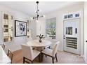 Cozy dining area with a round table, white chairs, and natural light streaming in from windows at 2035 Belmont Terraces Ln # 5, Charlotte, NC 28205