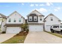 New construction home features a three-car garage with a mix of stone and gray board and batten siding at 7059 Duncan Acres Dr, Belmont, NC 28012