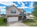 Charming two-story home with red brick accents, attached two-car garage and inviting front porch at 7206 Sandown Ct, Harrisburg, NC 28075