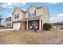 Two-story house with a beige exterior, brick accents, and a covered porch at 7206 Sandown Ct, Harrisburg, NC 28075