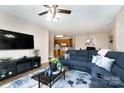 Cozy living room features a plush blue sectional, modern entertainment center, and open access to the kitchen at 11264 Hyde Pointe Ct, Charlotte, NC 28262