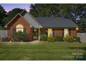 Exterior view of a brick home featuring a well maintained lawn, shrubbery, and inviting entrance at 6909 Green Haven Ln, Monroe, NC 28110