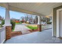 Inviting front porch view with brick pillars, white railings, and a glimpse of the neighborhood street at 3004 Ridge Ave, Charlotte, NC 28208