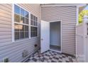 Outdoor patio with tiled floor, window, and access door, perfect for enjoying private outdoor space at 563 Goldstaff Ln, Charlotte, NC 28273
