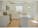 A well-lit kitchen featuring white cabinetry, stainless steel appliances, and a center island at 816 Fairview St # B, Kannapolis, NC 28083
