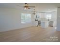 An open-concept living space with light hardwood floors and a view into the modern kitchen at 816 Fairview St # B, Kannapolis, NC 28083